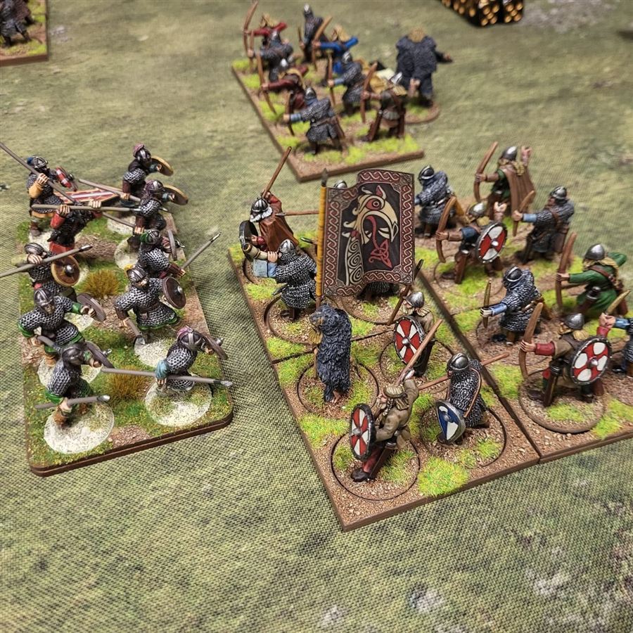 Painted Saxon and Viking warbands, with archers and a war banner, clashing on a grassy battlefield